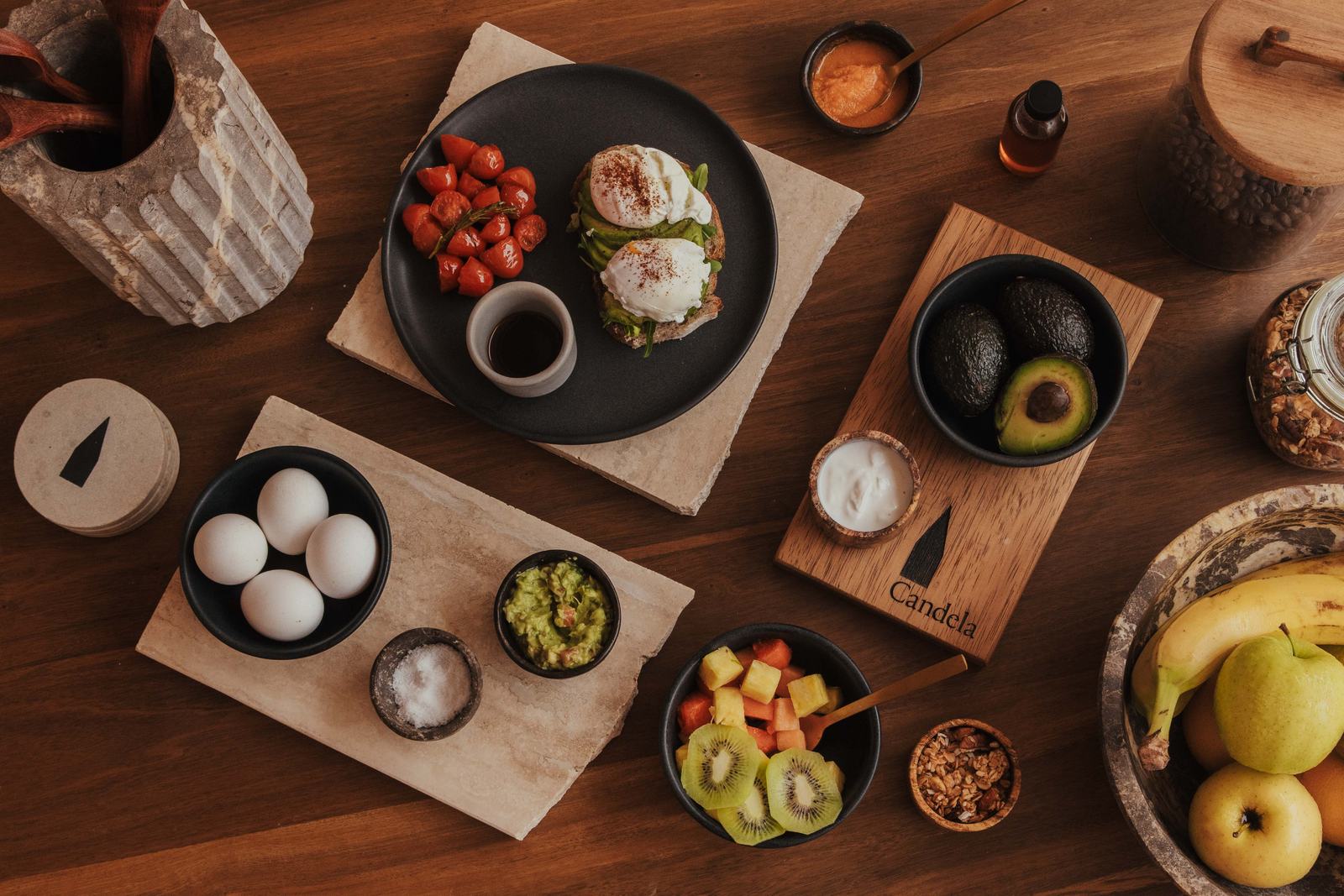 Breakfast spread of fruit, eggs, avocado and local honey on a wooden table