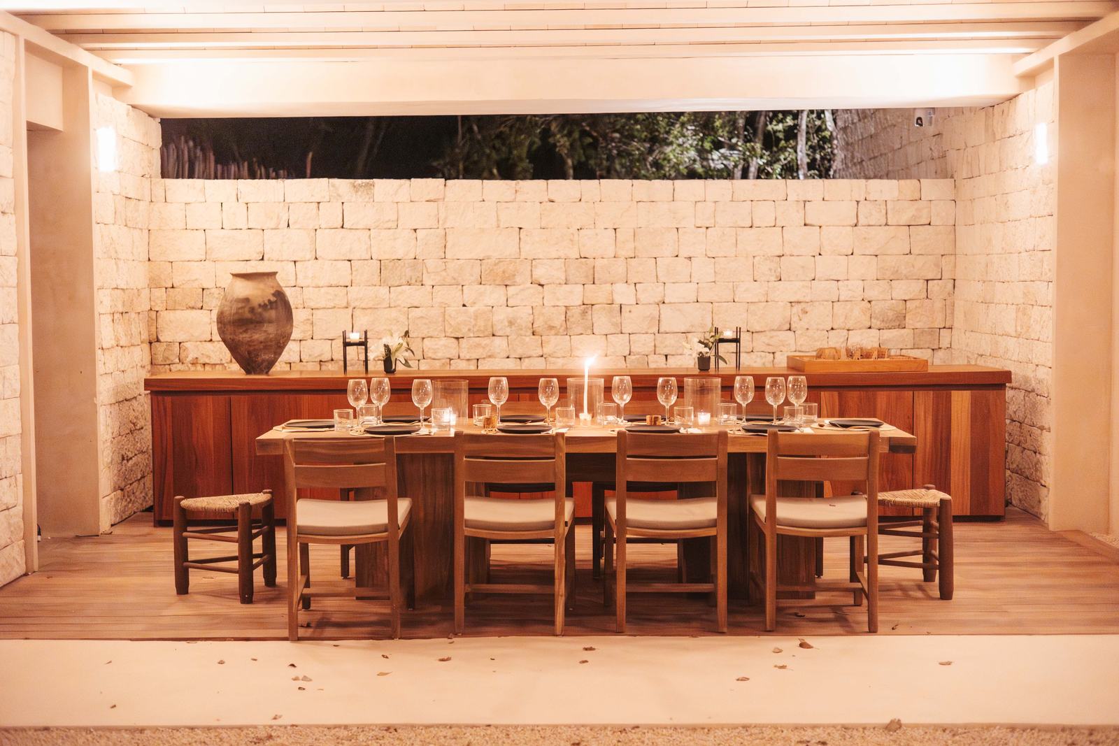Long candlelit dining table in a stone room
